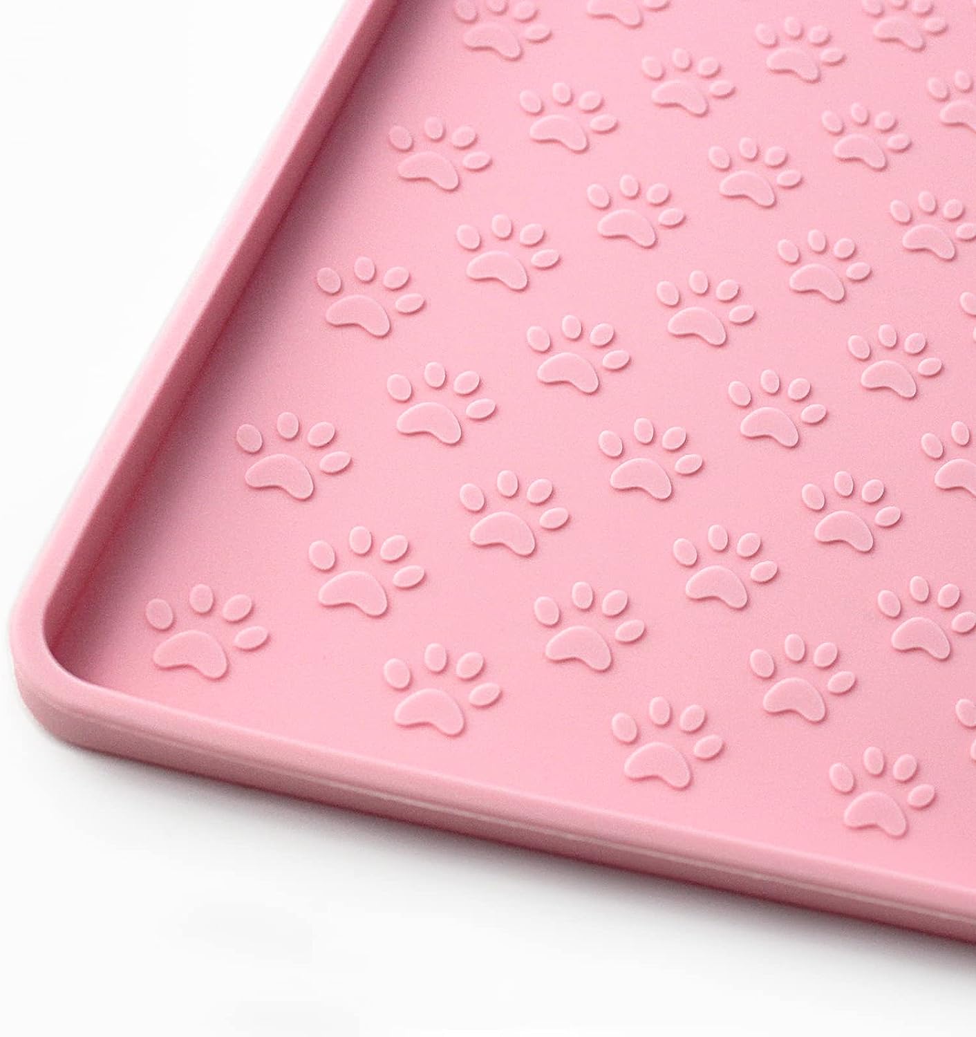 Pink silicone mat with paw print pattern for pet feeding messes.