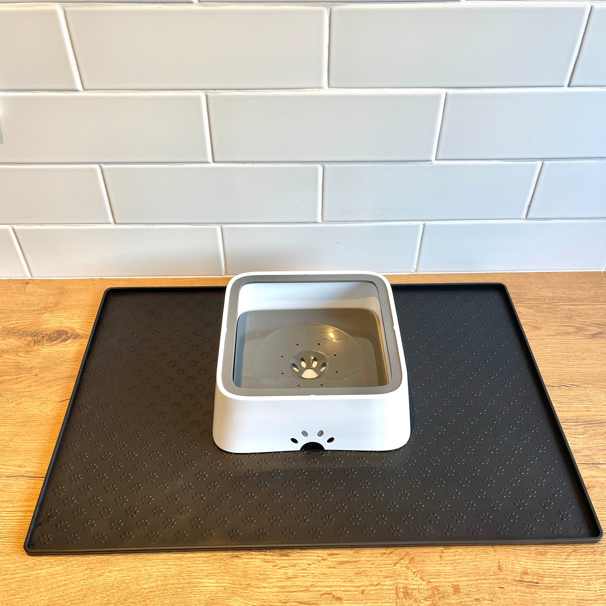 Silicone feeding mat with a white dog bowl, featuring raised edges to prevent spills.